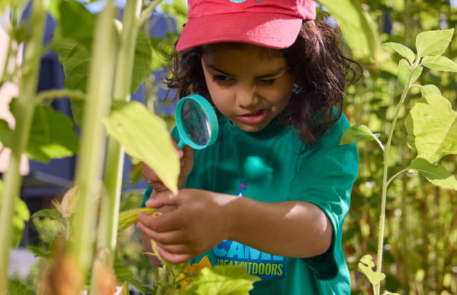 Girl with magnifying glass outside